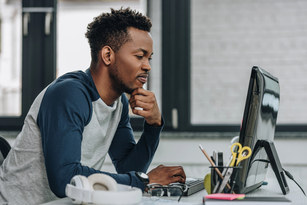 Software developer working on lotto analysis code at a desk
